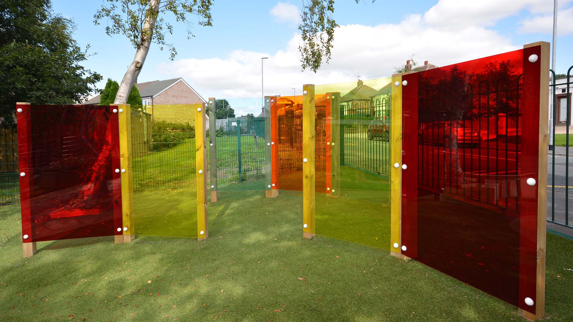 Coloured translucent play panels on timber posts, on a school field