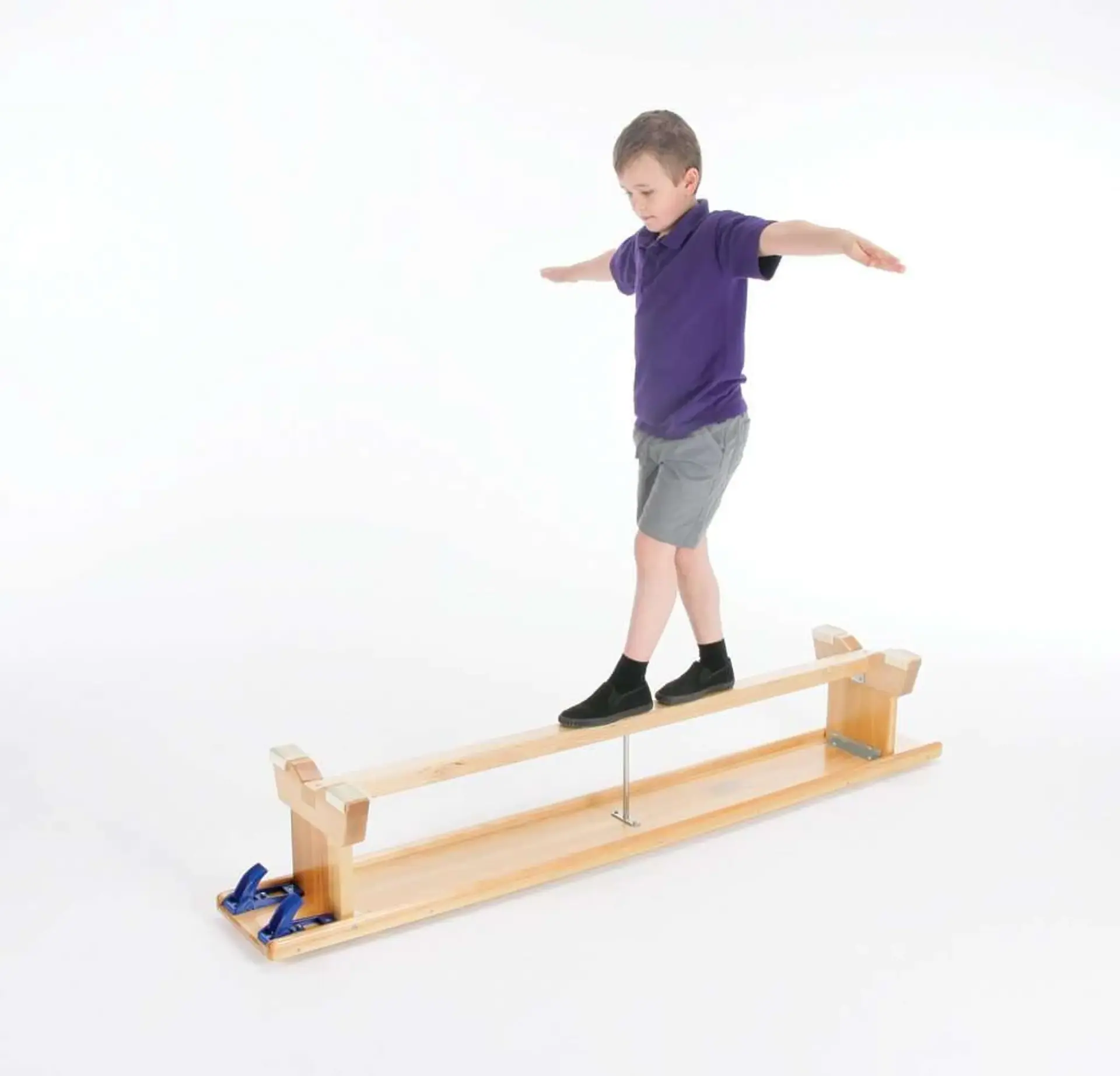 Child on a flipped balance bench practising balancing.