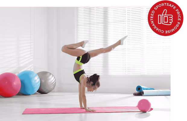 A woman performing a handstand on a yoga mat, showcasing strength and balance in a serene environment.