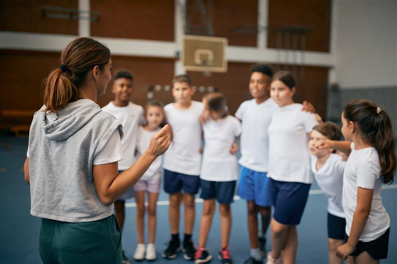 Sports teacher explaining lesson to class