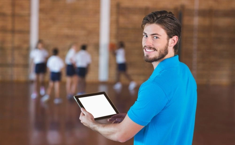 PE teacher using ipad to teach lesson
