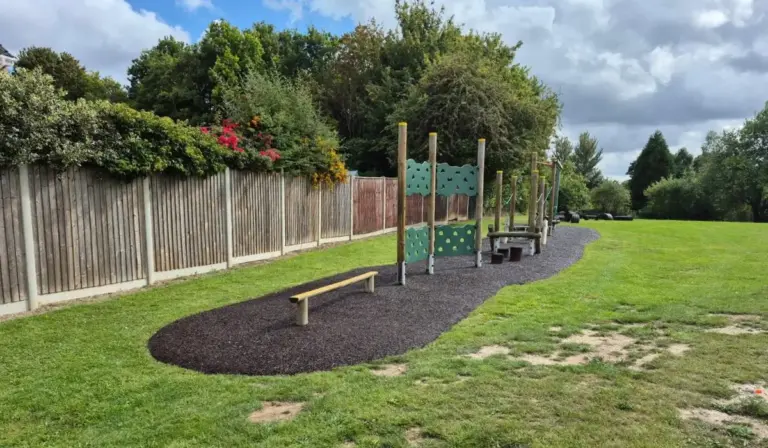 Wooden play equipment with rubber mulch around it