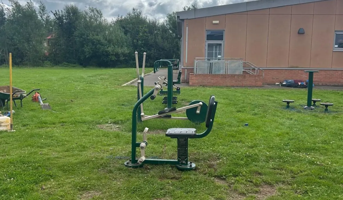 Outdoor fitness equipment at a school in green and beige