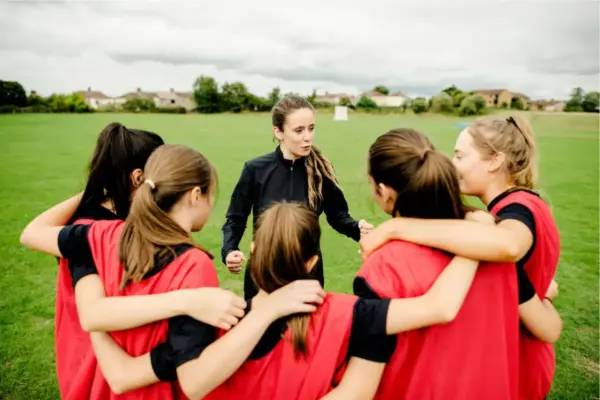 All girls team huddled around their coach