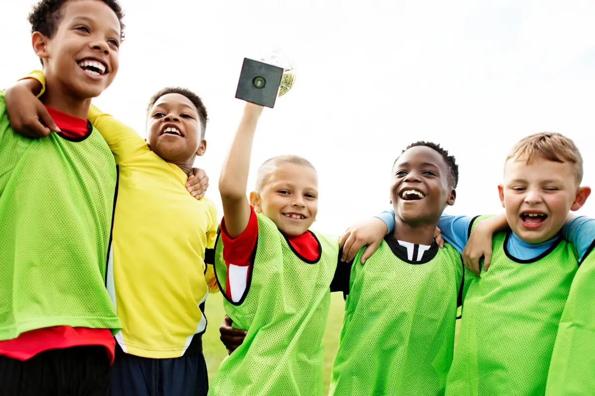 School boys celebrating winning a football match