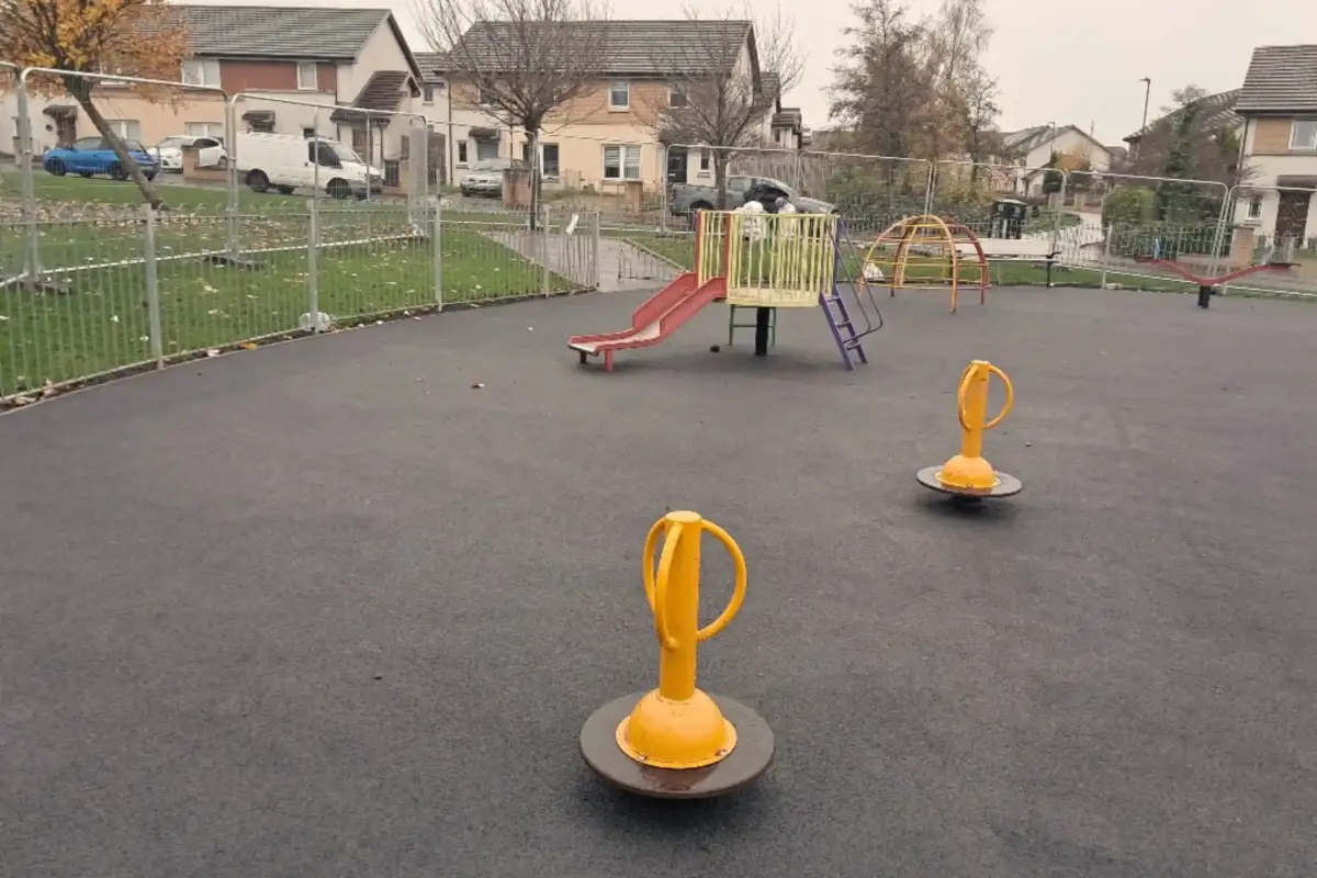 Play park with black wetpour surfacing.