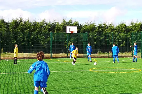 Outdoor Sports and Playground Installation - Team playing football on a MUGA (Multi-use games area)