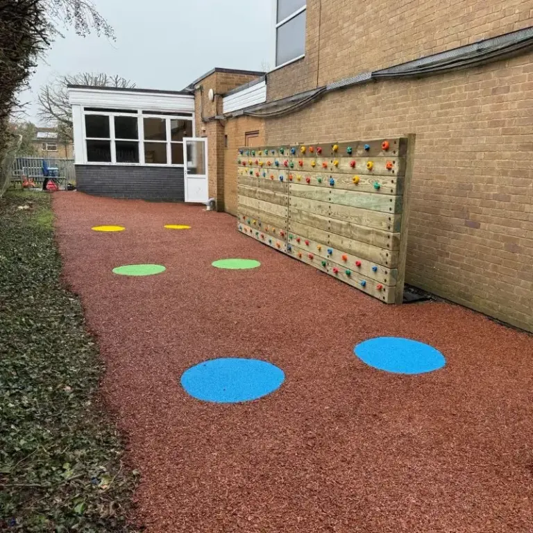 Traverse walll surrounded by rubber mulch with activity circles